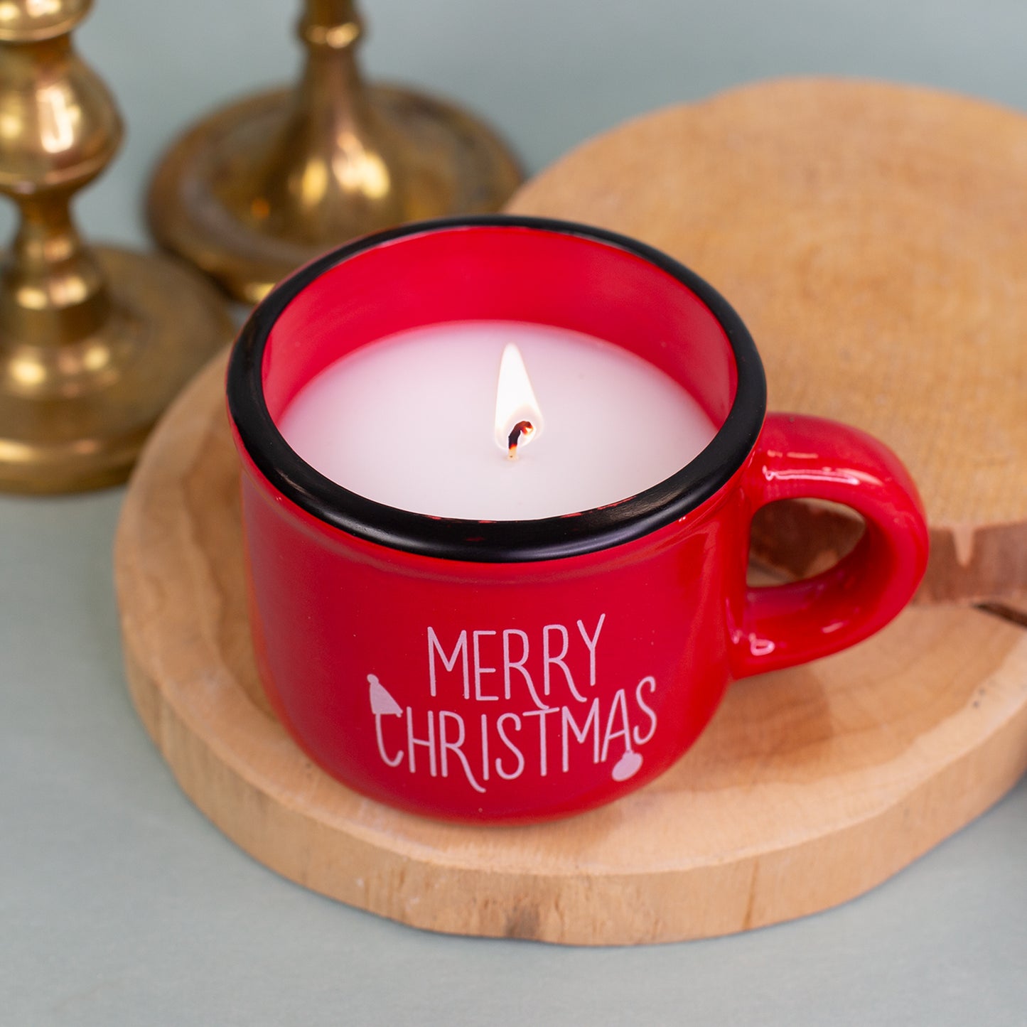 Brennende Kerze in roter Dolomitetasse Merry Christmas, festlich dekoriert