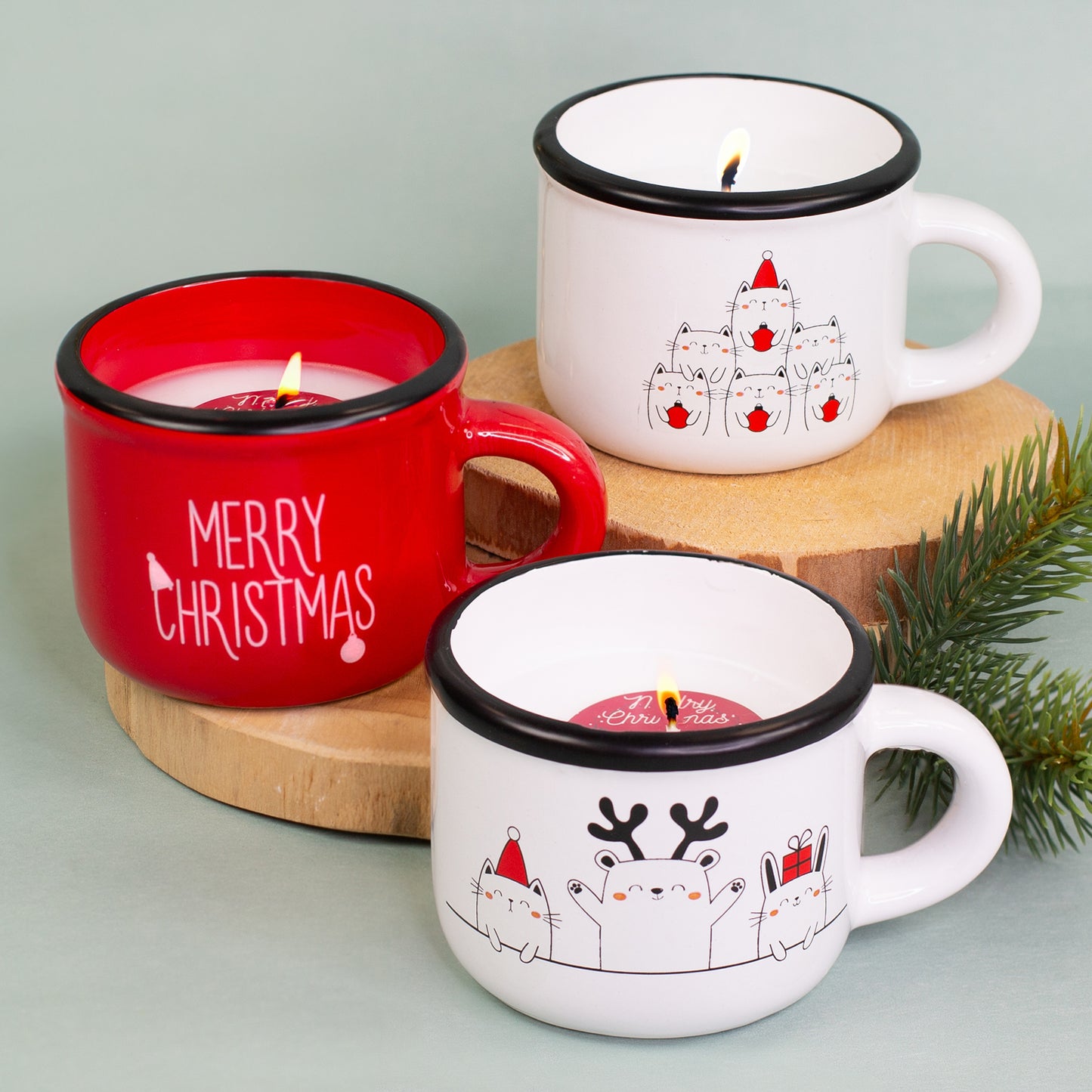 Drei Weihnachtskerzen in Dolomitetassen in Rot und Weiß mit weihnachtlichen Motiven auf Holzuntergrund