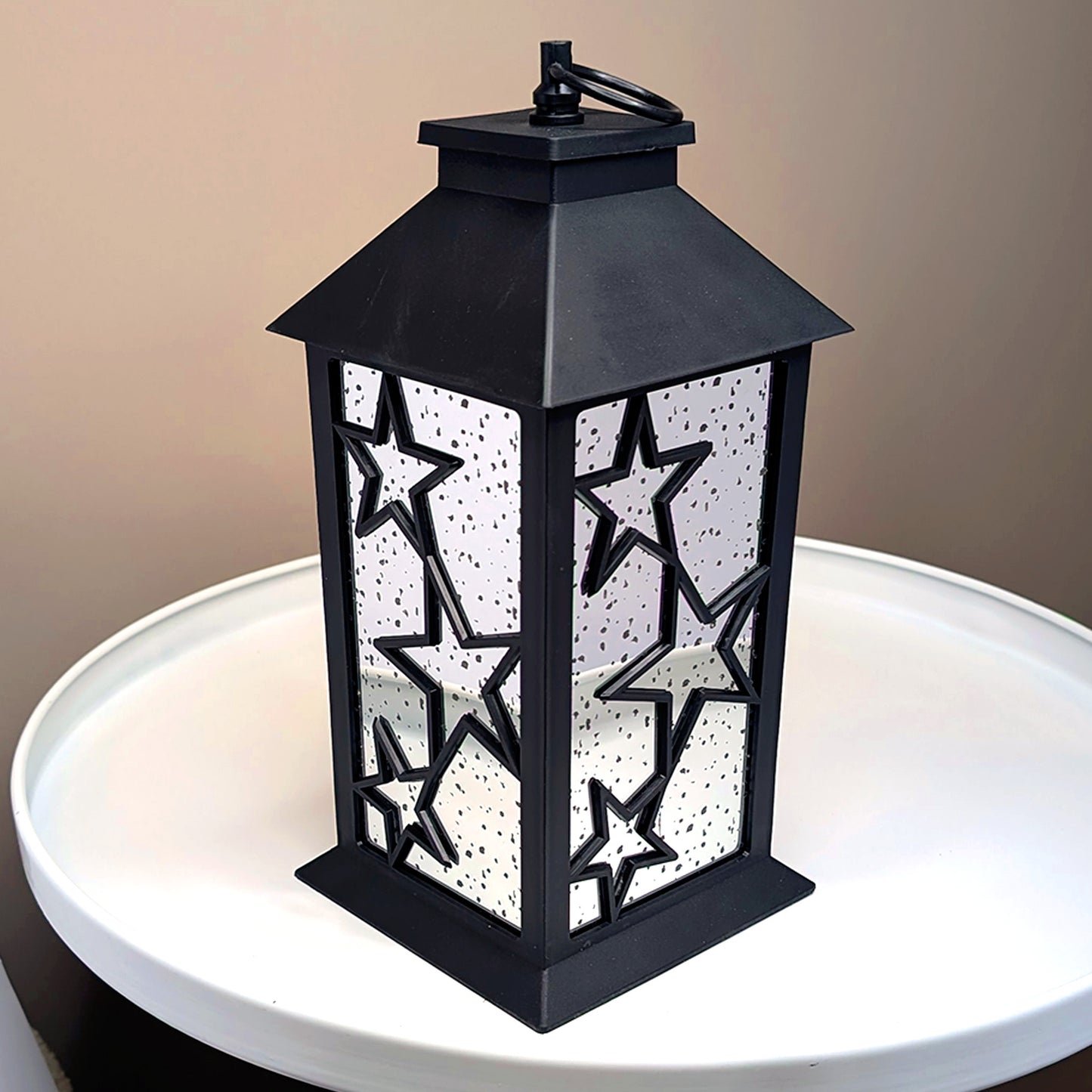 LED-Weihnachtslaterne mit Spiegelwänden und Sternendesign auf weißem Tisch