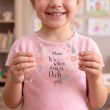 Kind hält transparenten Acryl Herz Anhänger mit Spruch und Name Mama