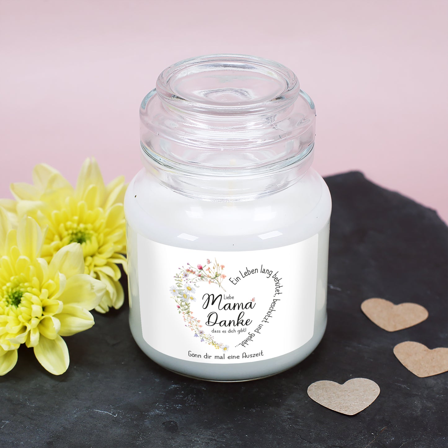 Weiße Duftkerze mit natürlichem Arganöl-Duft in einem hochwertigen Glasgefäß mit Deckel. Das Etikett zeigt ein liebevoll gezeichnetes Wiesenblumen-Herz, das den Schriftzug „Ein Leben lang behütet, beschützt und geliebt…“ umrahmt. In der Mitte steht „Liebe Mama, Danke, dass es dich gibt!“. Die Personalisierung lautet hier „Gönn dir mal eine Auszeit“. Perfekte Geschenkidee für Entspannung und Wertschätzung.
