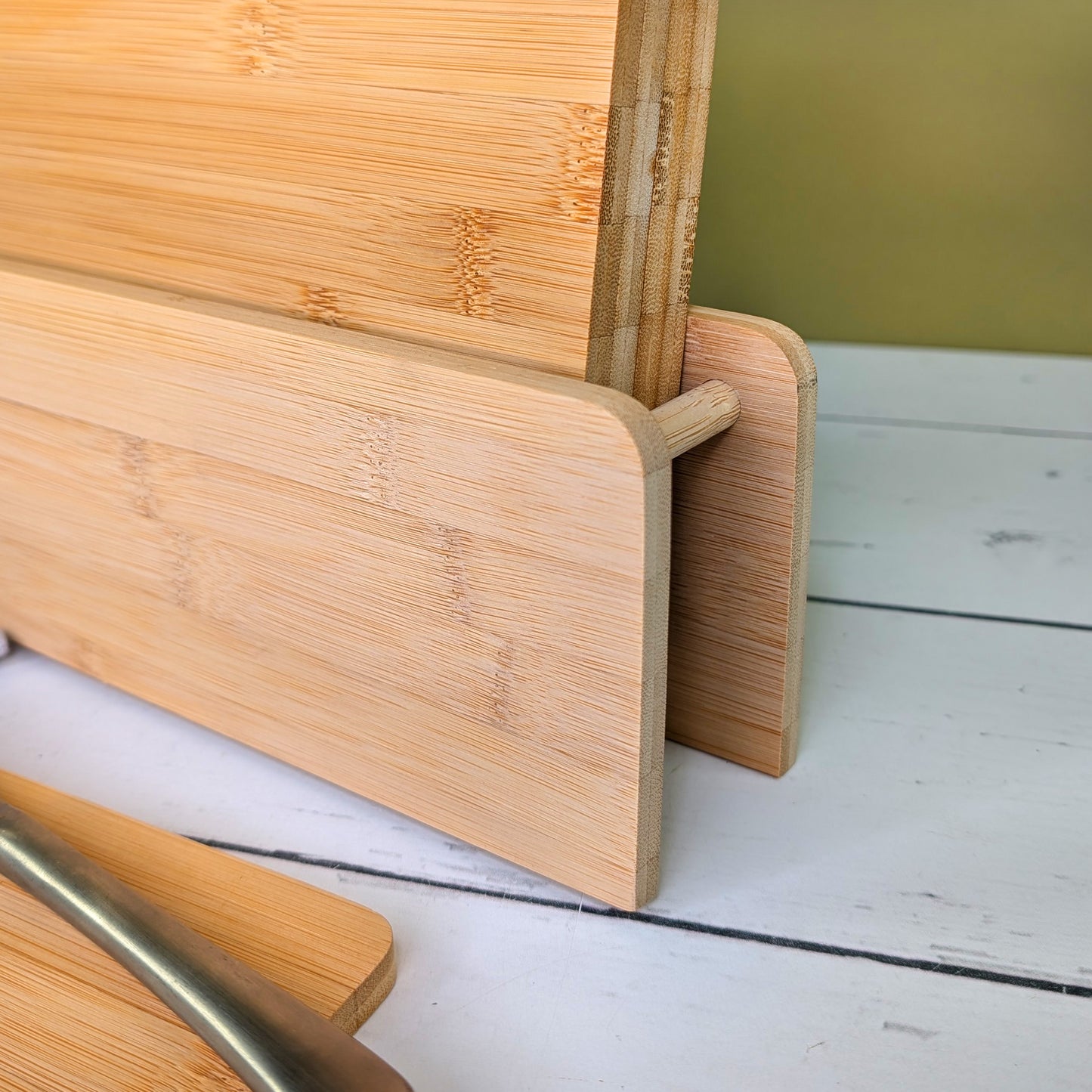 Nahaufnahme des seitlichen Ständers mit eingefassten Bambusbrettchen, Fokus auf der Verarbeitung und Materialstruktur.