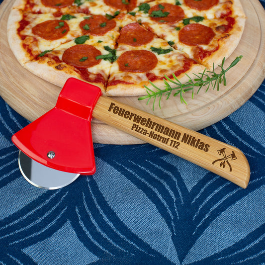 Personalisierter Pizzaschneider Feuerwehr Axt mit Gravur auf Bambusgriff neben Pizza