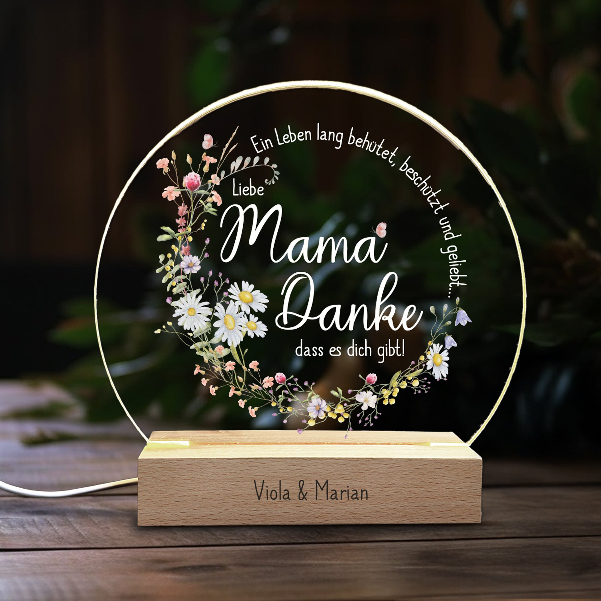Personalisiertes LED-Nachtlicht für Mama mit filigranen Frühlingsblumen und dem Spruch „Ein Leben lang behütet, beschützt und geliebt... Liebe Mama, Danke, dass es dich gibt!“. Die Acrylplatte wird von einem warmweißen LED-Licht beleuchtet, der Holzsockel ist mit einer individuellen Gravur personalisierbar. Perfektes Geschenk zum Muttertag oder als liebevolle Aufmerksamkeit.