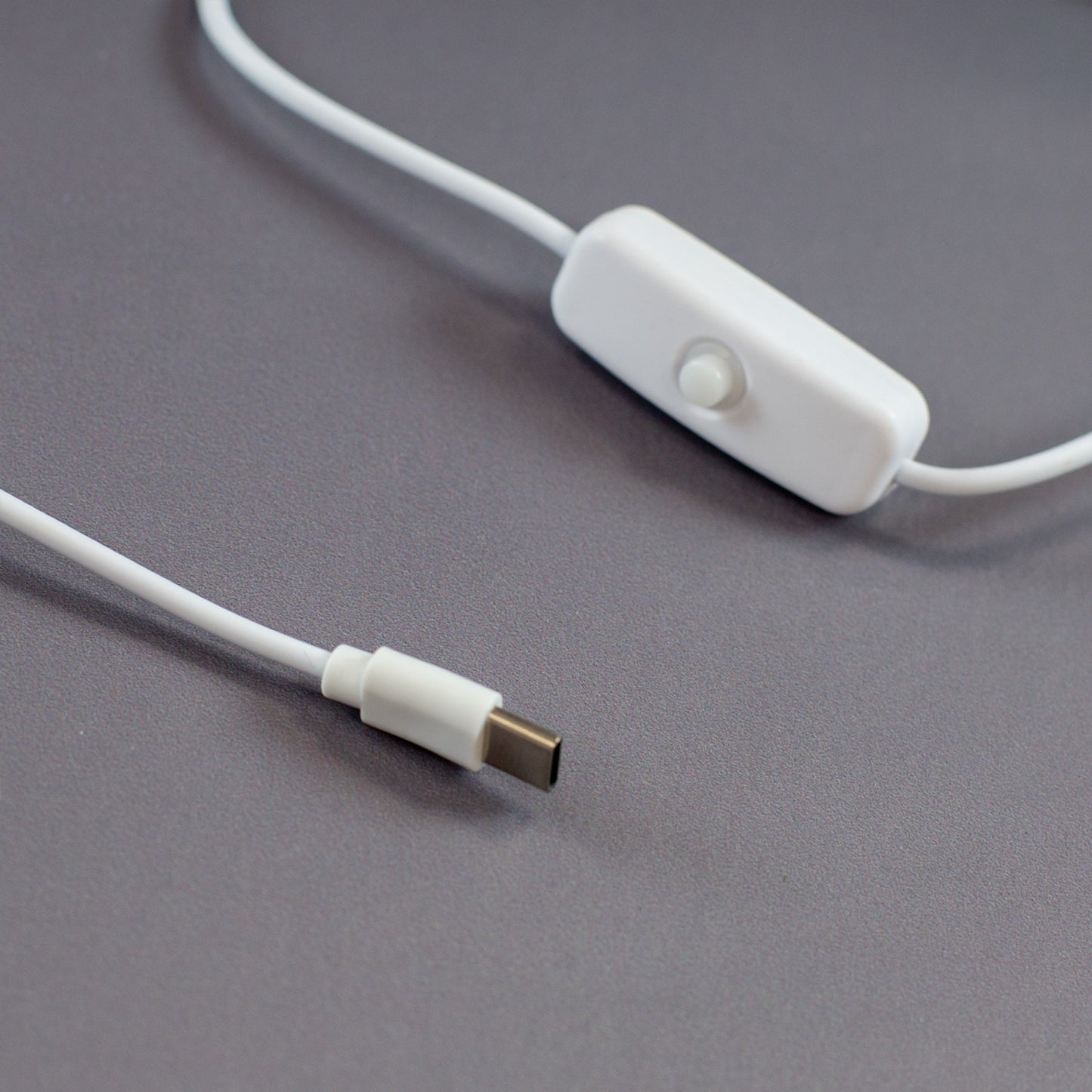 Detailaufnahme des weißen USB-C-Kabels mit integriertem Ein-/Ausschalter. Das Kabel gehört zur LED-Acryllampe und ermöglicht eine einfache Bedienung. Der Schalter sorgt für bequemes Ein- und Ausschalten, während der moderne USB-C-Anschluss eine zuverlässige Stromversorgung gewährleistet.