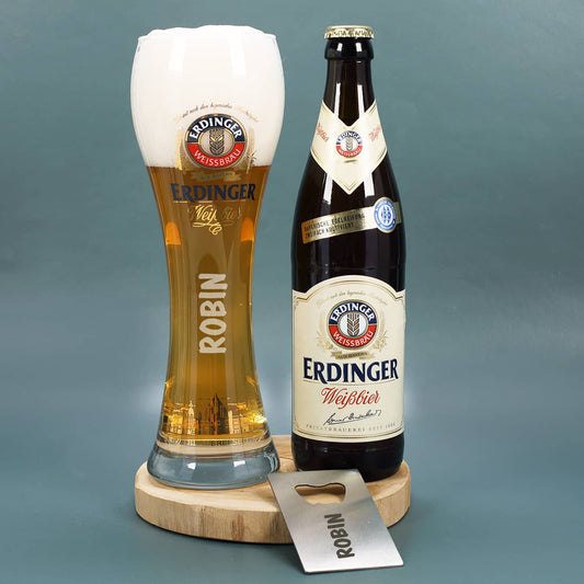 Erdinger Weißbier und Weizenglas und Flaschenöffner auf Holzscheibe