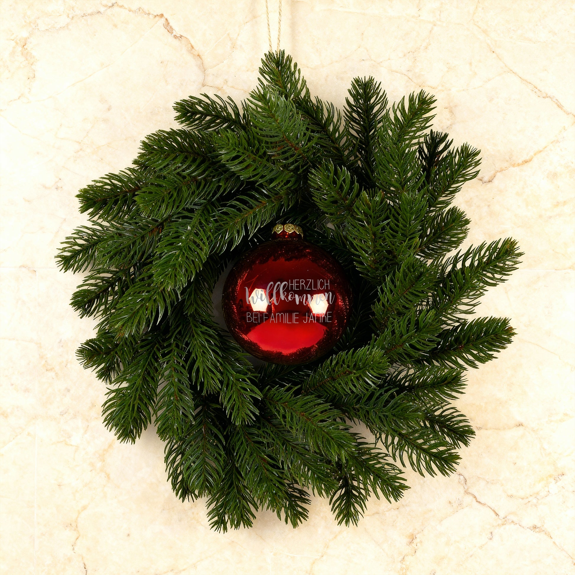 Türkranz mit roter gravierter Willkommens-Kugel auf hellem Steinuntergrund