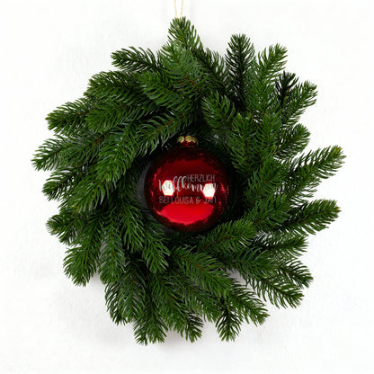 Weihnachts-Türkranz mit roter Kugel „Herzlich willkommen“ auf weißem Hintergrund