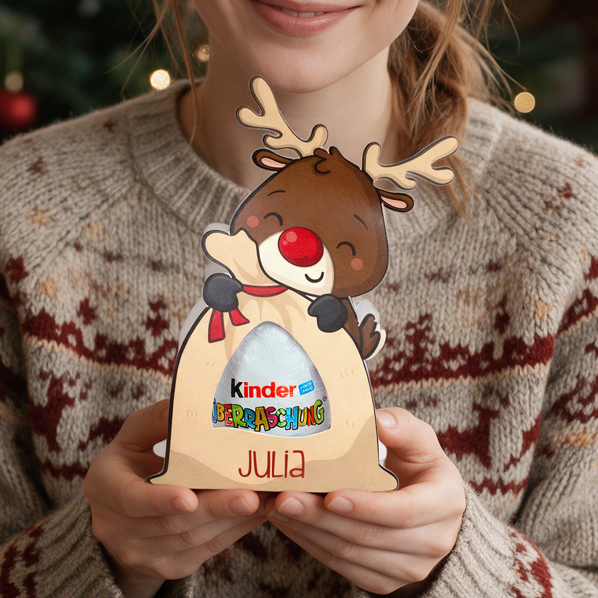 Personalisierte Rentier-Verpackung mit Kinder Überraschung und Name Julia als kleines Weihnachtsgeschenk in den Händen