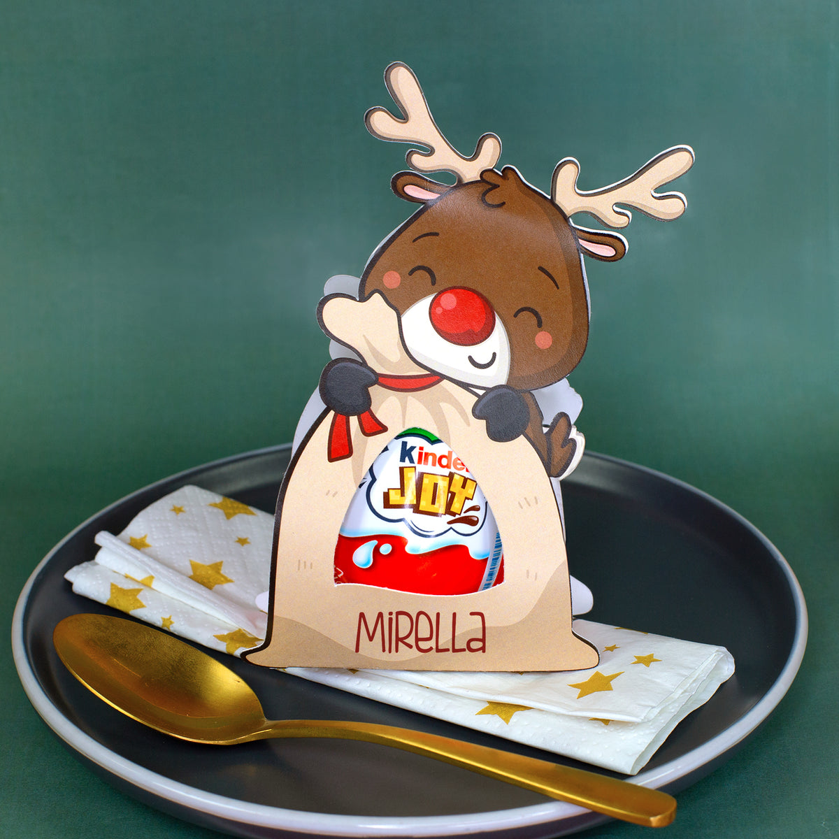 Rentier-Geschenkverpackung mit Kinder Joy und personalisiertem Namen Mirella als Platzkarte auf einem Weihnachtsteller