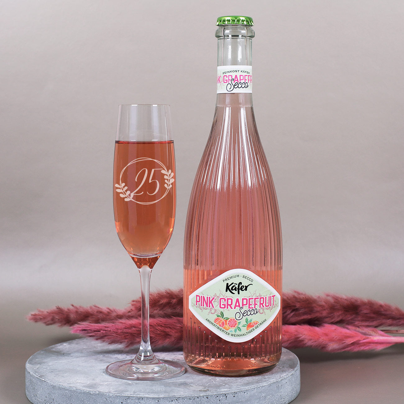 Sektglas mit Alter und Blütenrahmen personalisiert, sowie Fruchtsecco in der Sorte Pink Grapefruit