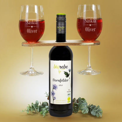 Zwei gravierte Weingläser mit den Namen Saskia und Oliver, Weinbutler-Holzhalter und Biorebe Dornfelder Rotwein 2023