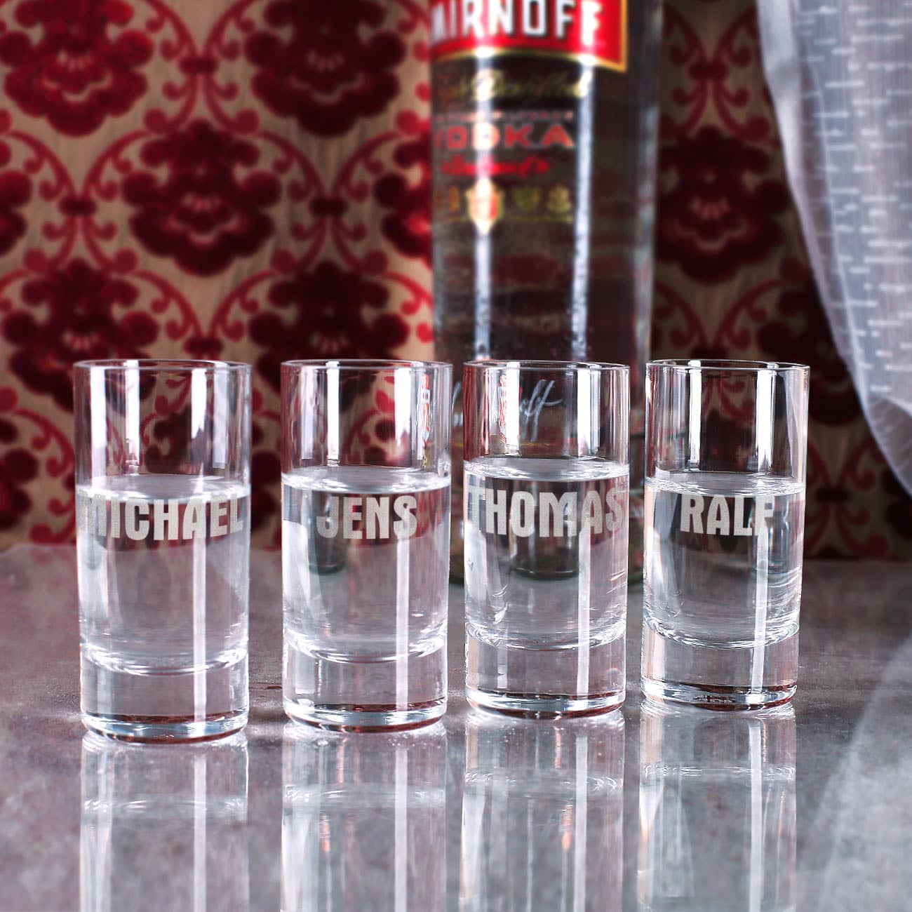 4 Vodka-Gläser werden mit 4 verschiedenen Namen graviert