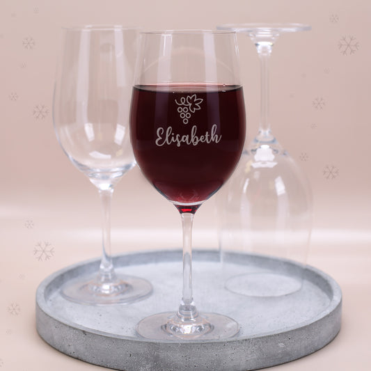 Leonardo Weinglas mit Gravur Motiv Traube und Name Elisabeth, gefüllt mit Rotwein auf Tablett mit weiteren Gläsern