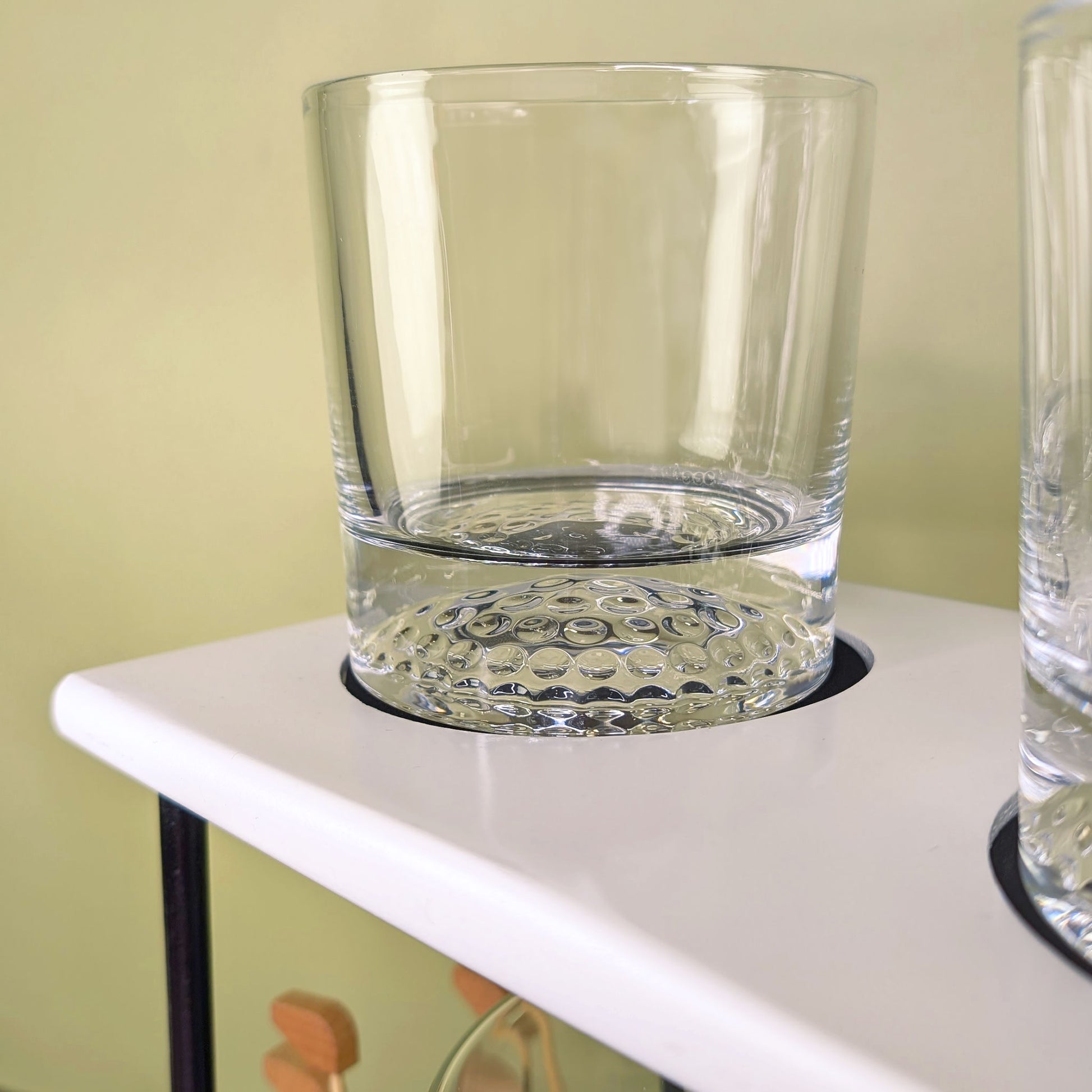 Detailaufnahme eines Glases mit Golfballstruktur am Boden