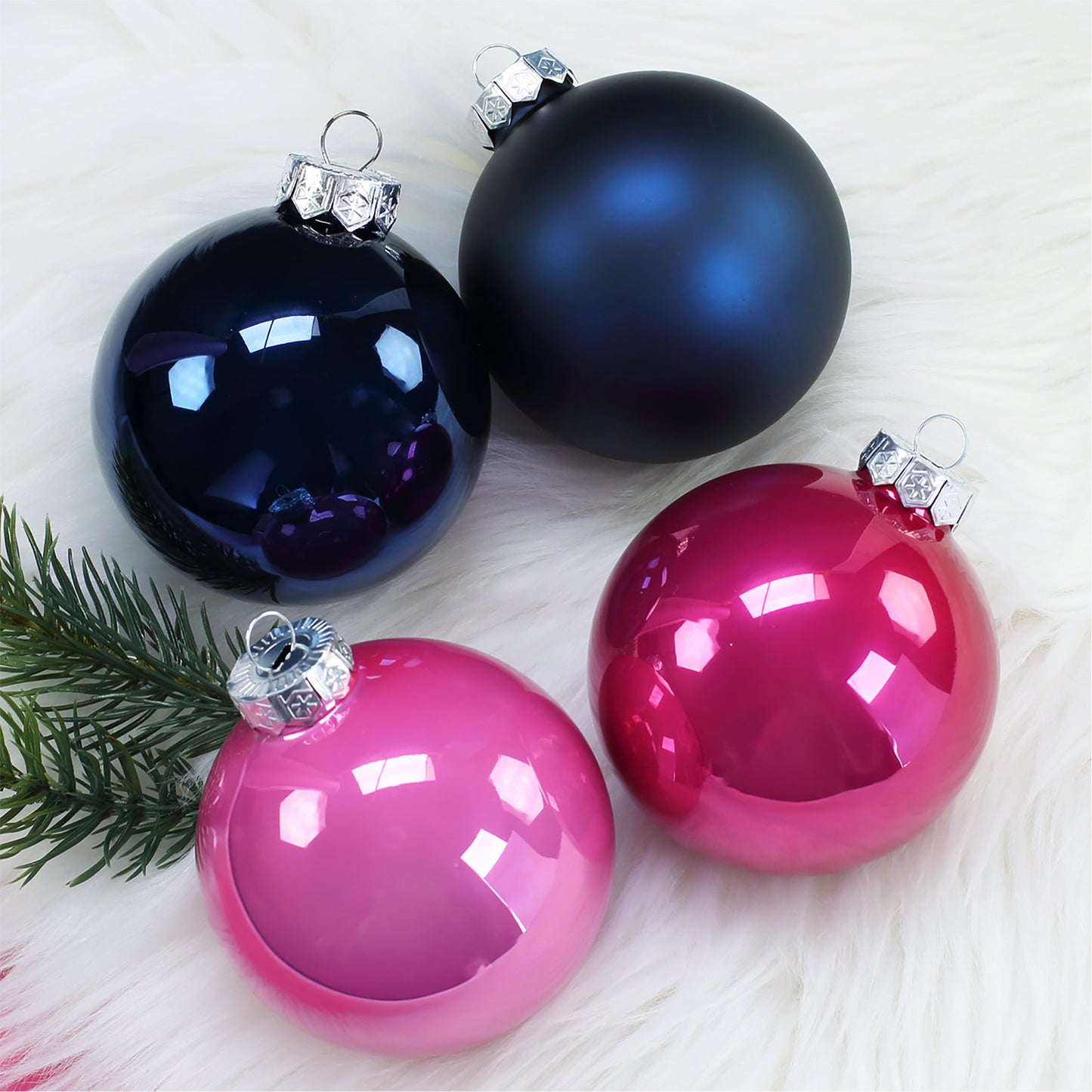 Vier Weihnachtsbaumkugeln in Pink und Dunkelblau in matter und glänzender Ausführung, gruppiert als Farbvarianten.