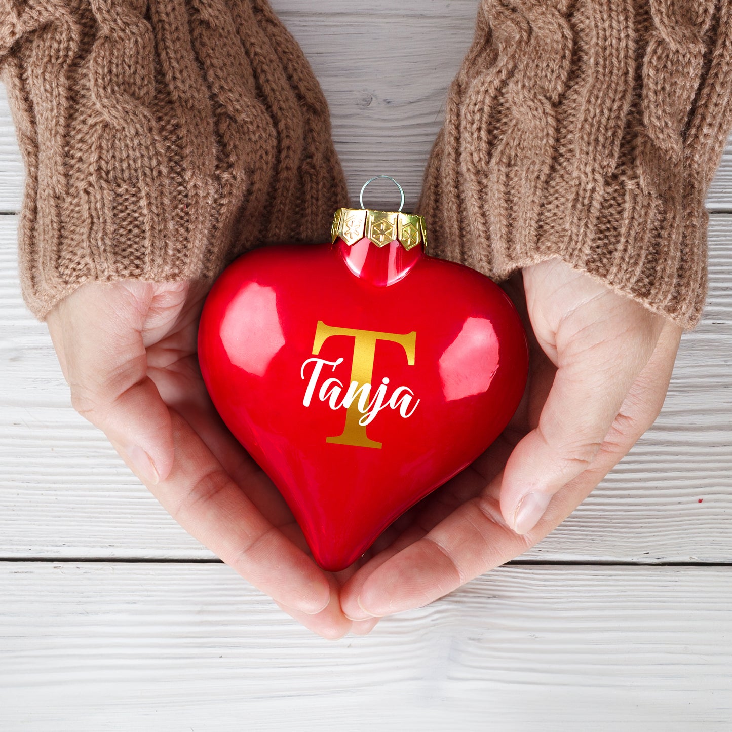 Personalisierte Weihnachtskugel mit Initiale T und Name Tanja in Händen gehalten