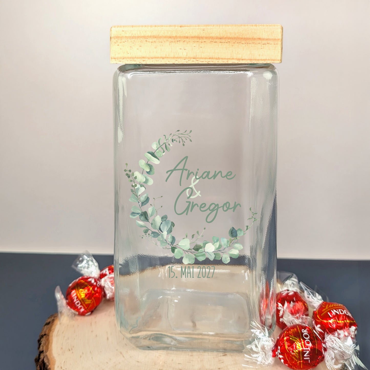 Glas mit Bambusdeckel, Eukalyptusmotiv auf Holzscheibe mit Schokokugeln dekoriert