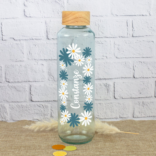Handgearbeitete Glas Trinkflasche mit Holzdeckel, Blumenkranz und Name Constanze auf natürlichem Hintergrund