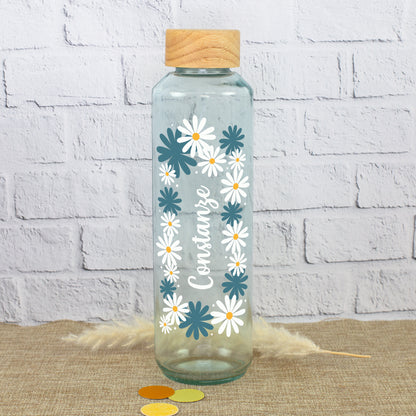 Handgearbeitete Glas Trinkflasche mit Holzdeckel, Blumenkranz und Name Constanze auf natürlichem Hintergrund