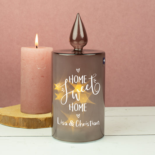 LED-Dekolicht aus Rauchglas mit „Home Sweet Home“-Motiv neben echter Kerze dekoriert