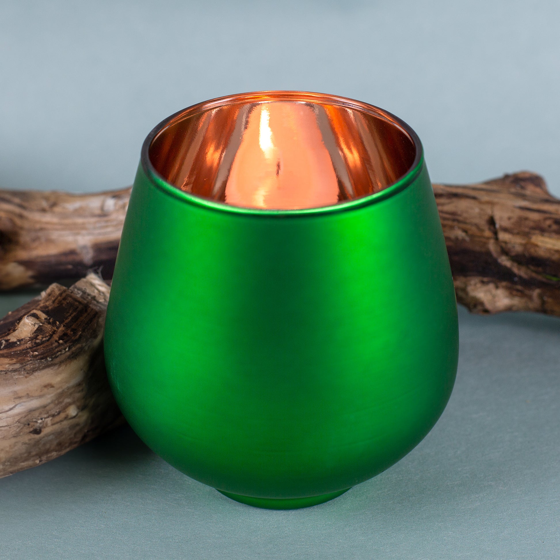 Rückseite des grünen Windlichts mit kupferfarbener Beschichtung und brennendem Teelicht