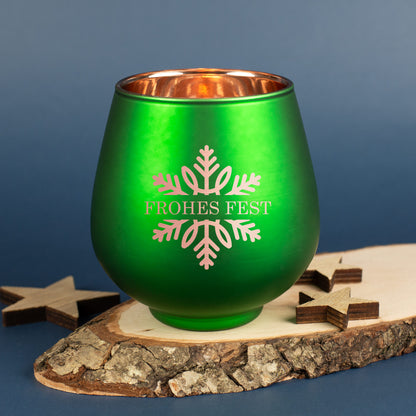 Grünes Windlicht mit Gravur „Frohes Fest“ und Schneeflockenmotiv auf Holzuntergrund