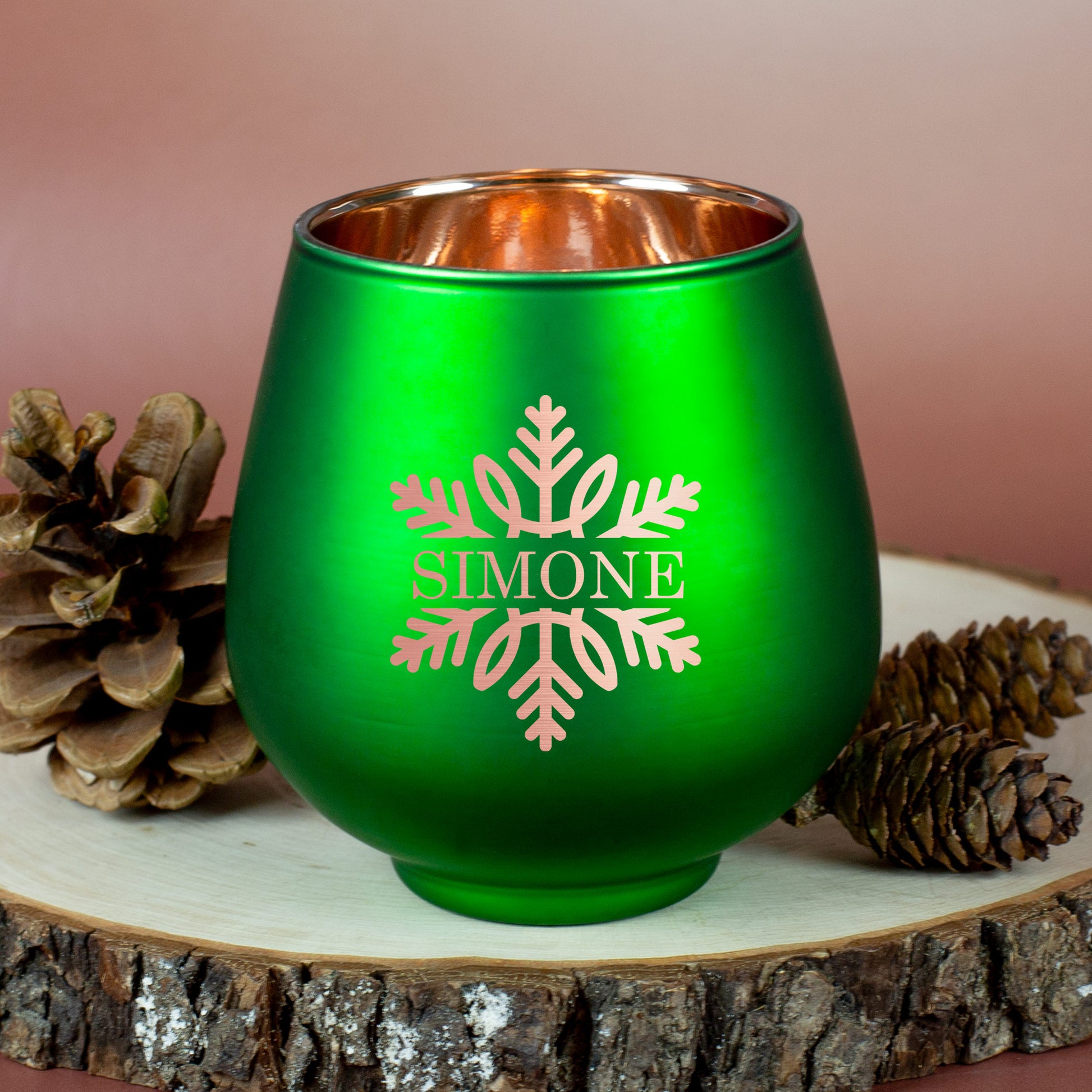 Grünes Windlicht mit Gravur „Simone“ und Schneeflocke, auf Holzscheibe mit Zapfen dekoriert