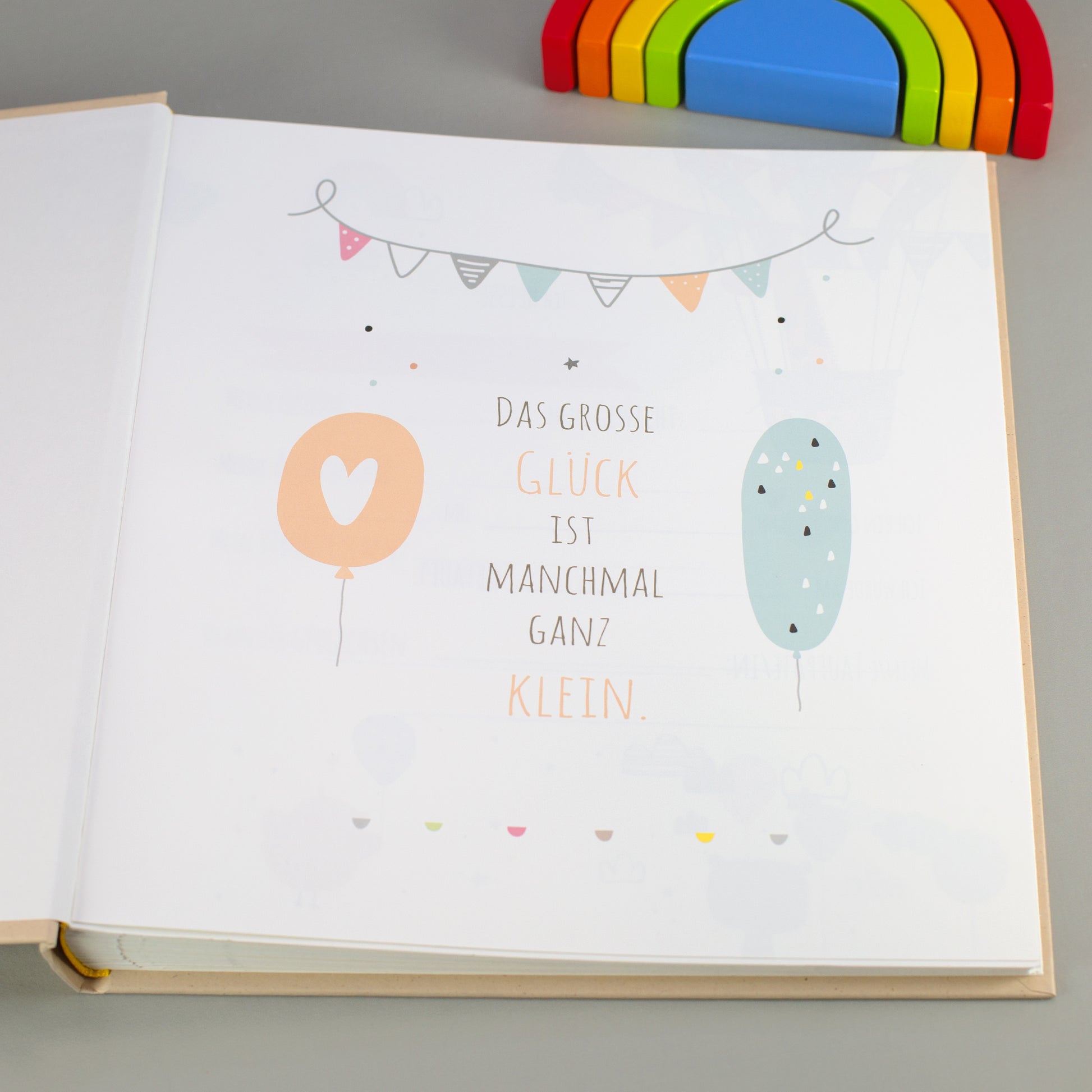 Illustrierte Innenseite mit Spruch „Das große Glück ist manchmal ganz klein“ im Babyalbum