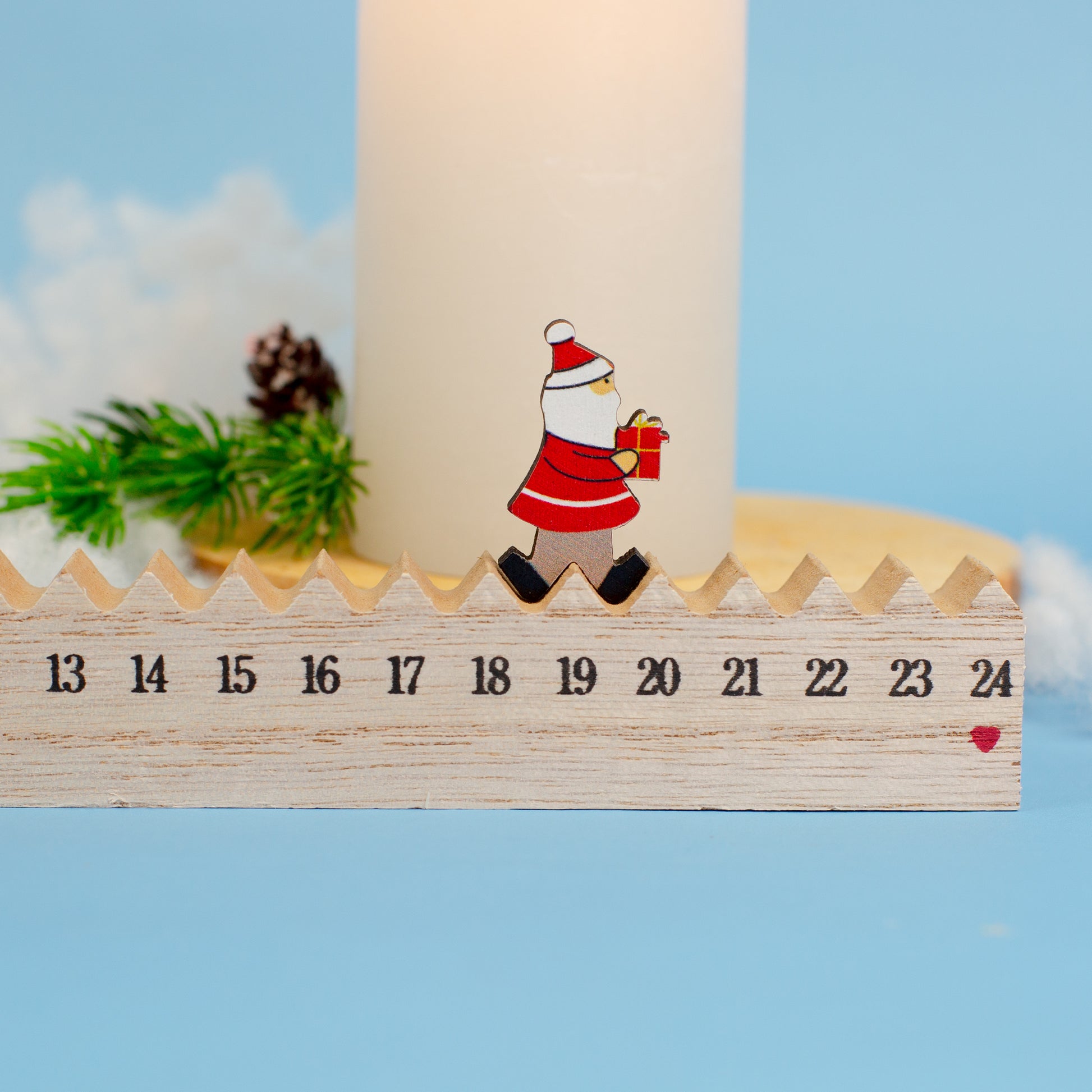 Adventskalender aus Holz mit Figur auf der Zahl 19, dekoriert mit Kerze und Tannenzweig