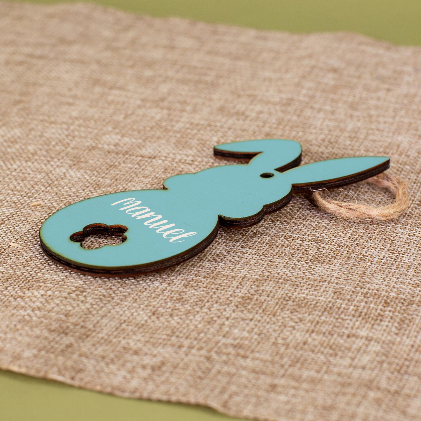 Personalisierter Holzanhänger in Hasenform in Blau mit Juteband, bedruckt mit dem Namen