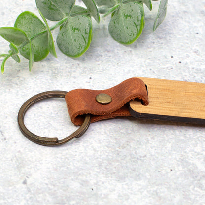Detailaufnahme vom braunen Lederband und Metallring des handgefertigten Schlüsselanhängers aus Holz
