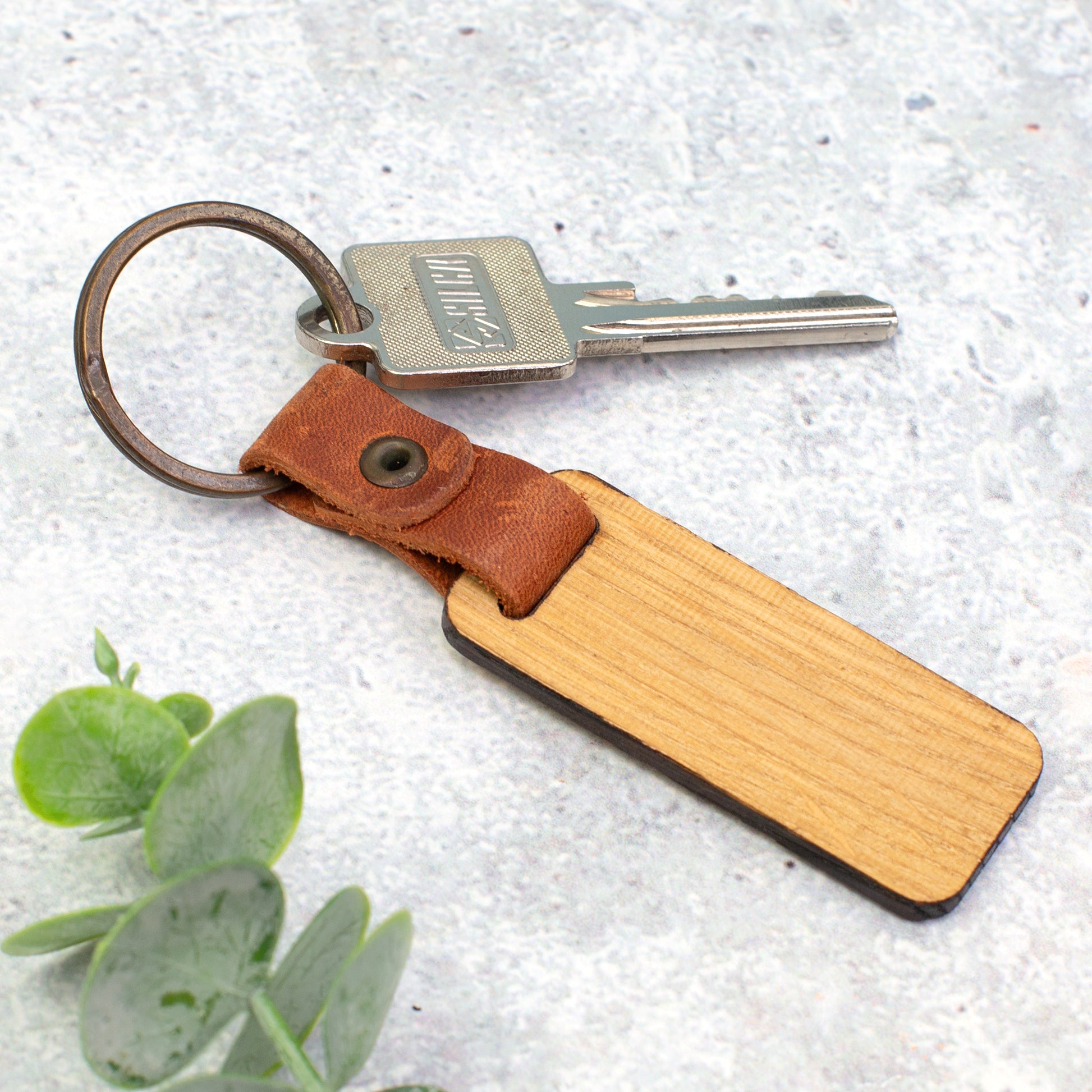 Rückseite des personalisierten Holz Schlüsselanhängers mit natürlicher Maserung, Lederband und Schlüsselring