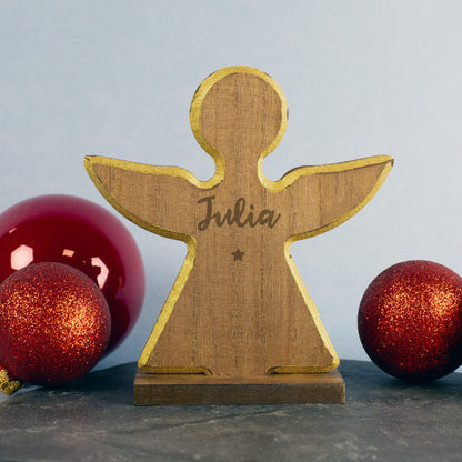 Nahaufnahme der feinen Holzstruktur und Gravur auf dem weihnachtlichen Stern, goldener Rand und Sockel gut sichtbar. ZU sehen ist die Variante: Engel.