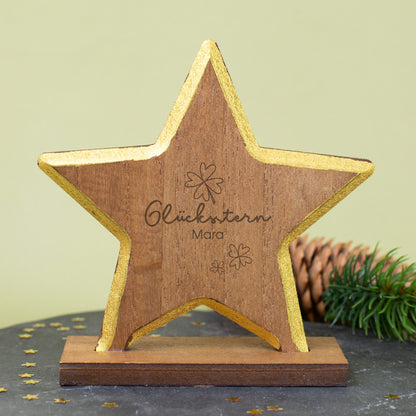 Nahaufnahme des gravierten Glückssterns mit Goldrand, Kleeblättern und Namensgravur auf Holz