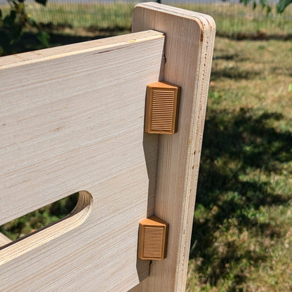 Zwei braune Clipverschlüsse an der Rückseite der Holzbank zur sicheren Befestigung der Rückenlehne aus naturbelassenem Holz