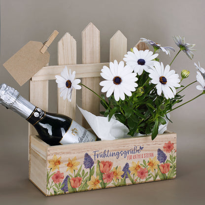 Geschenkkorb mit Zaun-Rückwand Frühlingsgrüße mit Wunschtext befüllt mit Blumen und Sekt