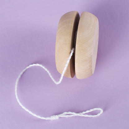 Seitenansicht des naturfarbenen Holz-Yo-Yos auf lila Untergrund