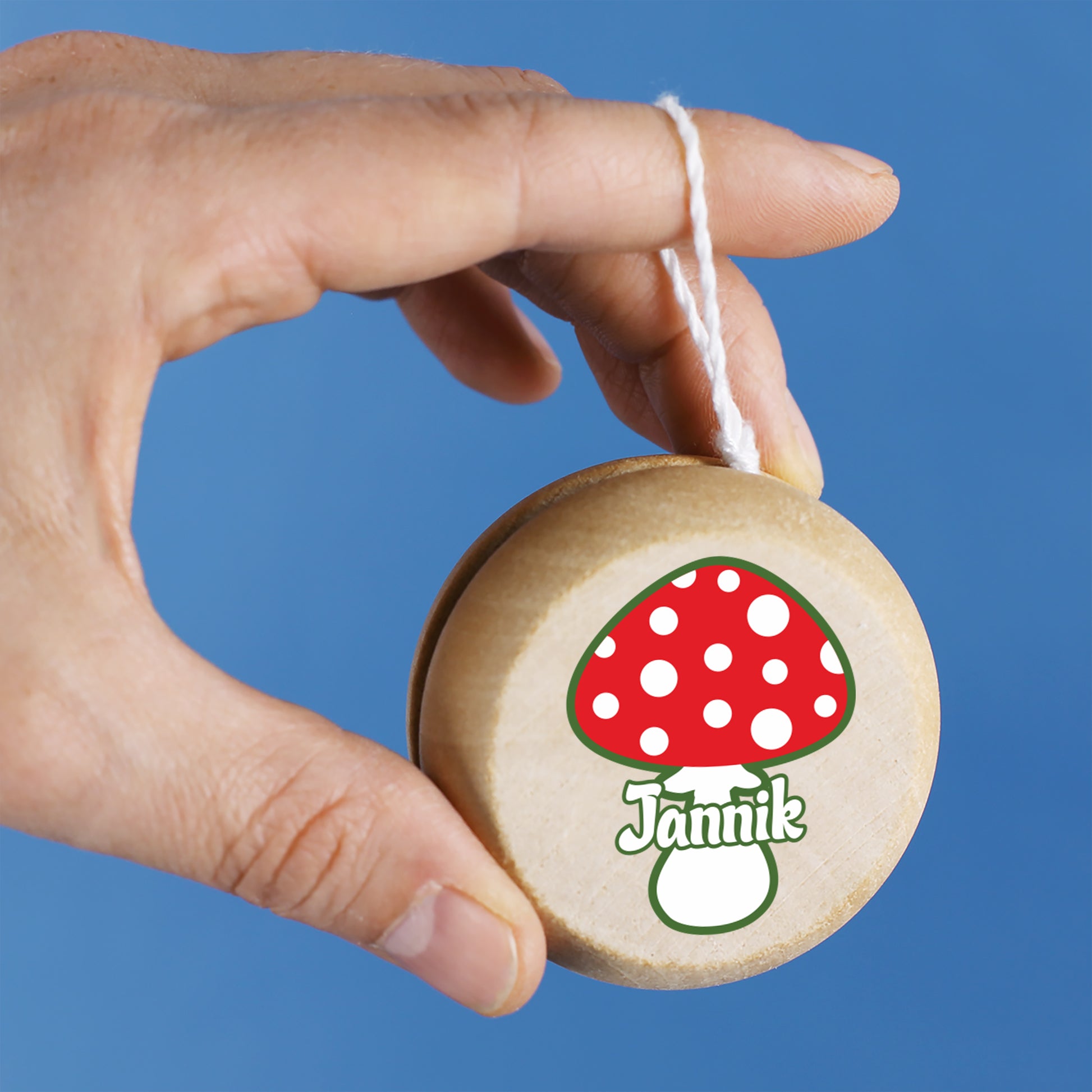 Nahaufnahme des Yo-Yos mit Pilzdesign, gut sichtbarer Namensdruck, gehalten von einer Hand