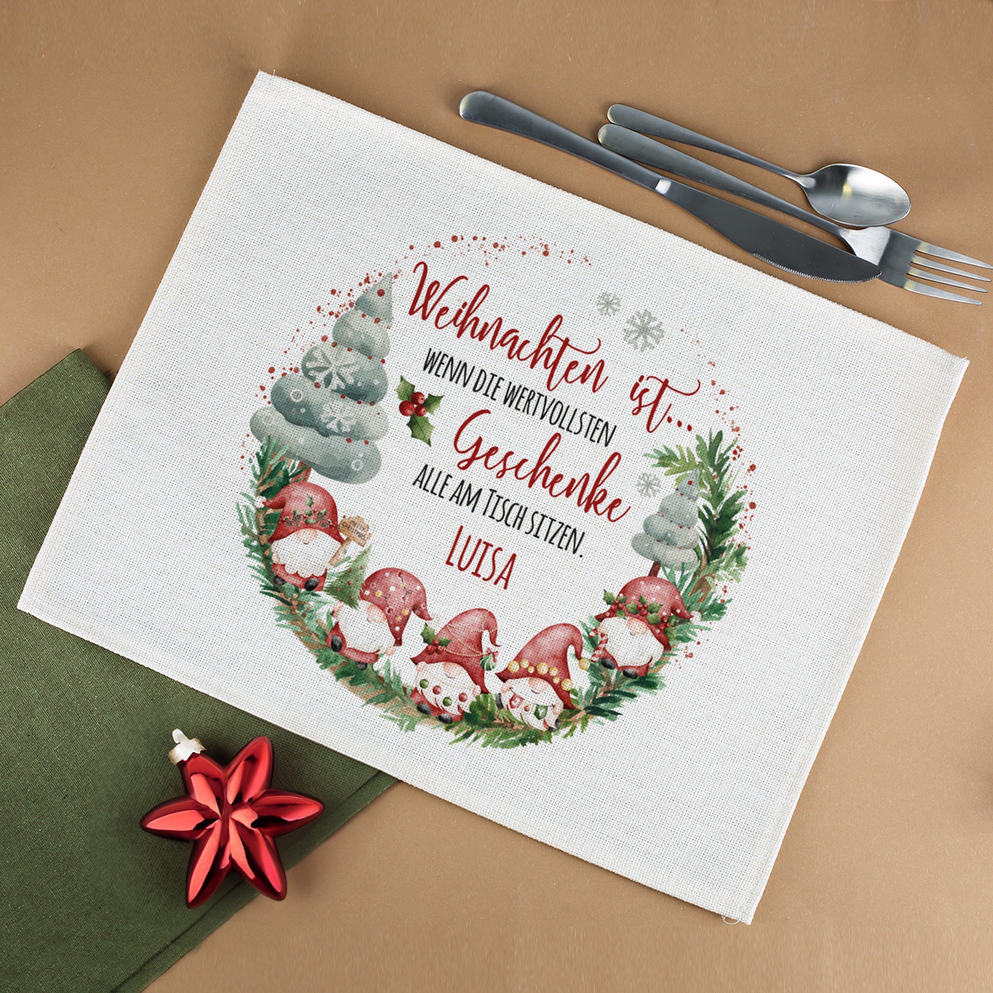 Platzdeckchen aus Jute mit Wichtelmotiv und personalisiertem Namen auf festlich gedecktem Tisch mit Besteck und Weihnachtsdeko.