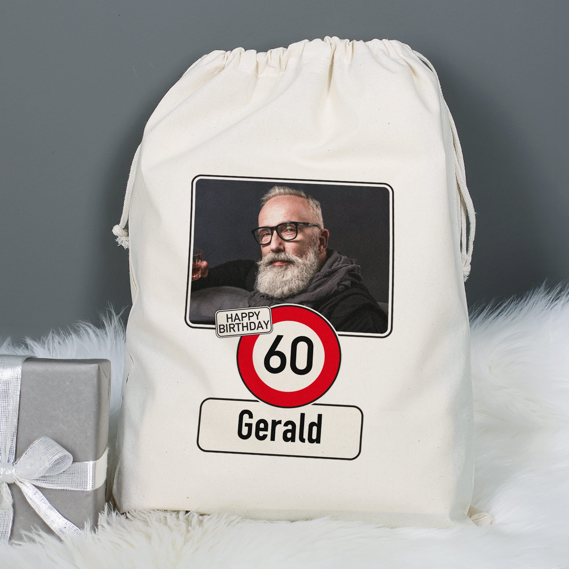 Großer Geschenksack mit personalisiertem Foto und Alter 60 für Gerald neben Geschenkbox