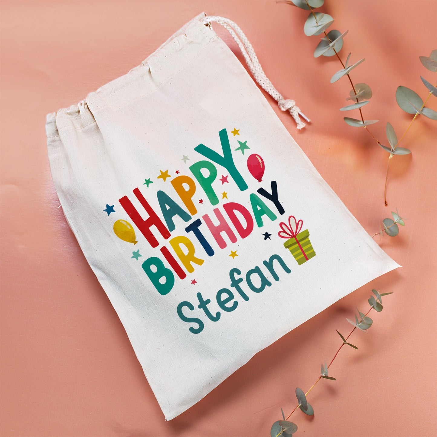 Mittelgroßer Stoffbeutel mit buntem Happy Birthday Motiv und individuellem Namen als Geschenkverpackung