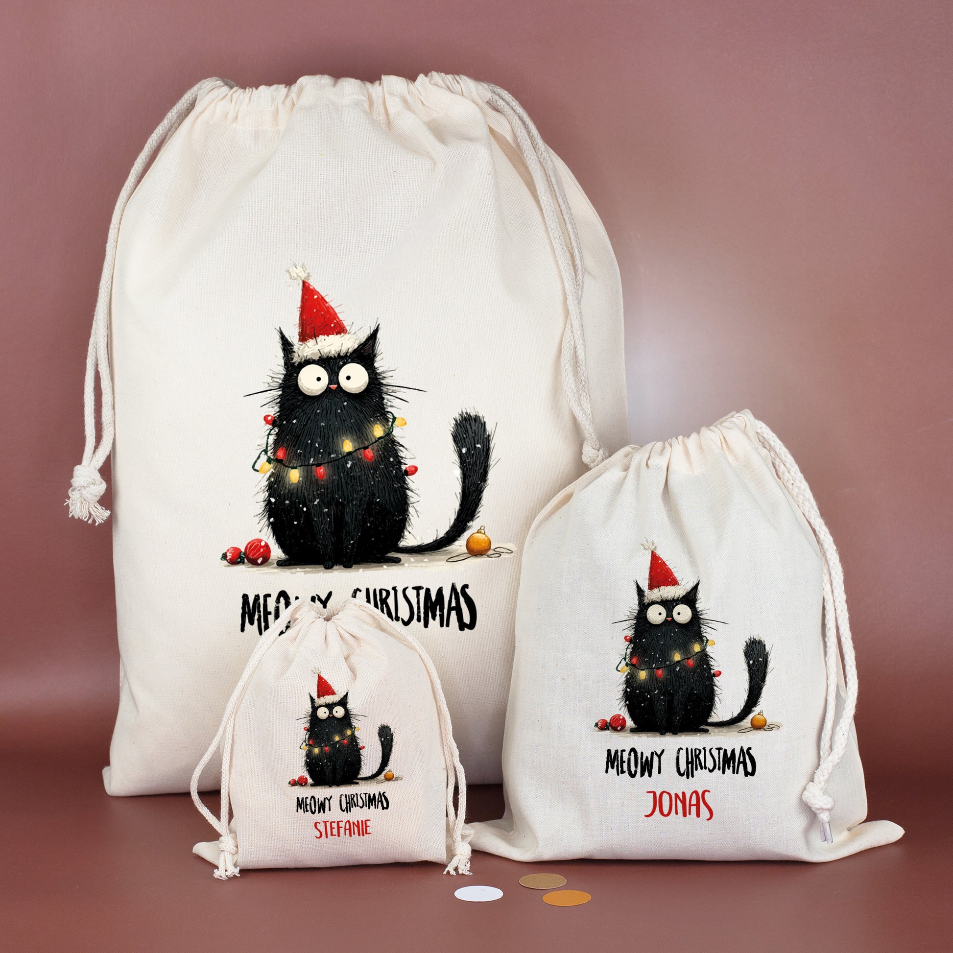 Drei Baumwoll-Geschenksäcke in unterschiedlichen Größen mit Katzenmotiv „Meowy Christmas“, personalisiert mit verschiedenen Namen