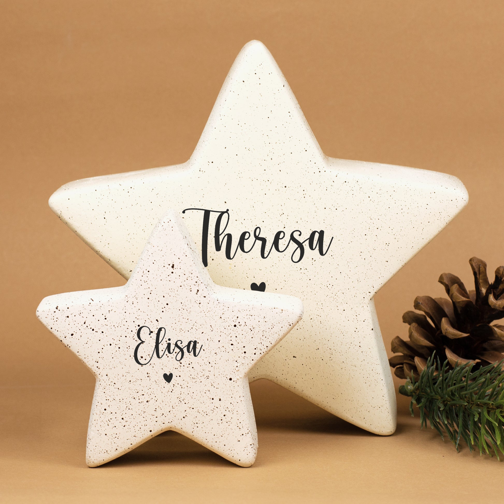 Kleiner und großer Keramikstern in Creme mit Personalisierung, Name „Elisa“ und Herzmotiv, weihnachtlich inszeniert.
