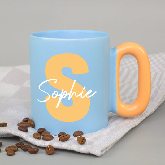 Blaue Tasse mit Initiale S und Name Sophie sowie orangefarbenem Griff