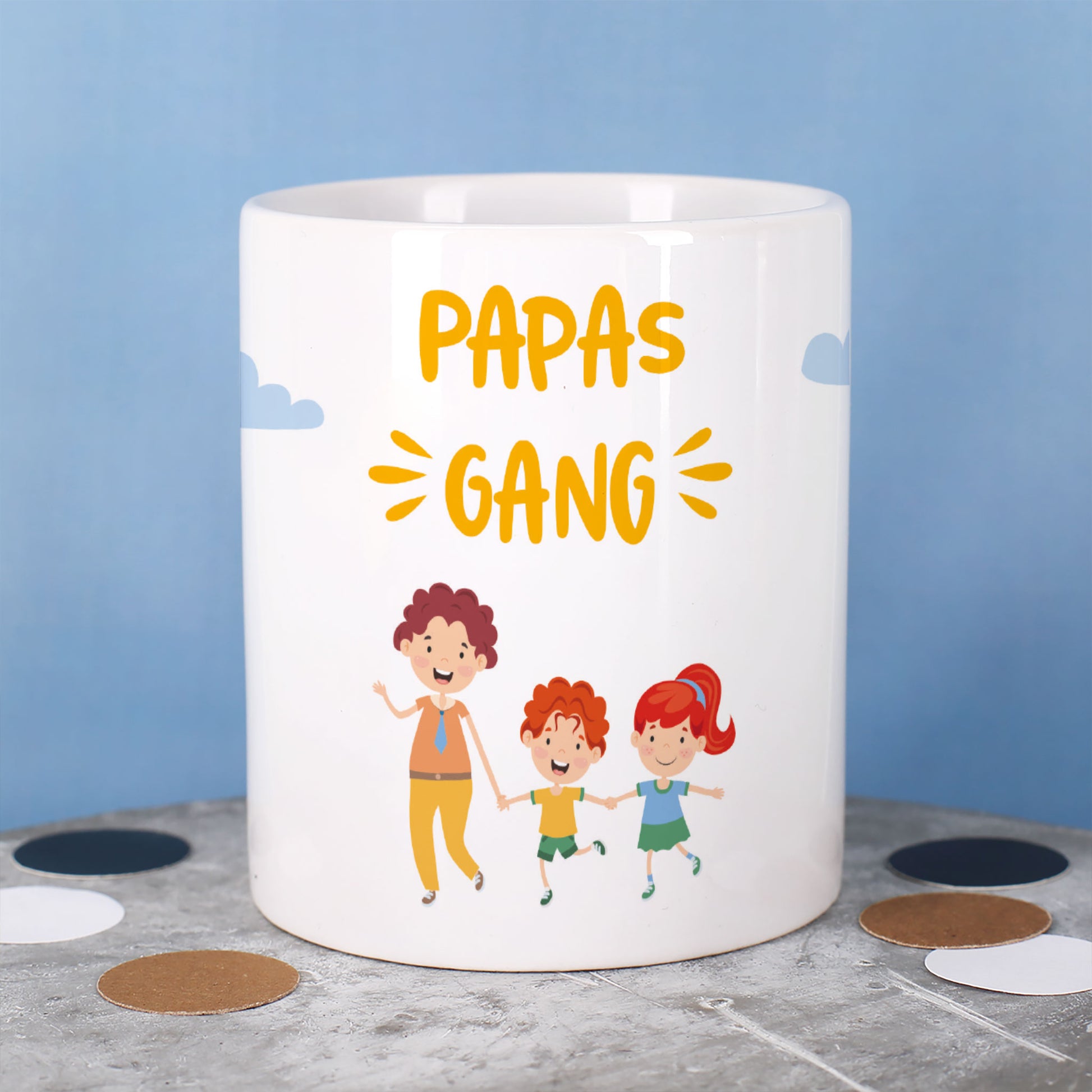 Tasse mit Text „Papas Gang“ und drei Figuren: ein Vater mit zwei Kindern, vor blauem Hintergrund