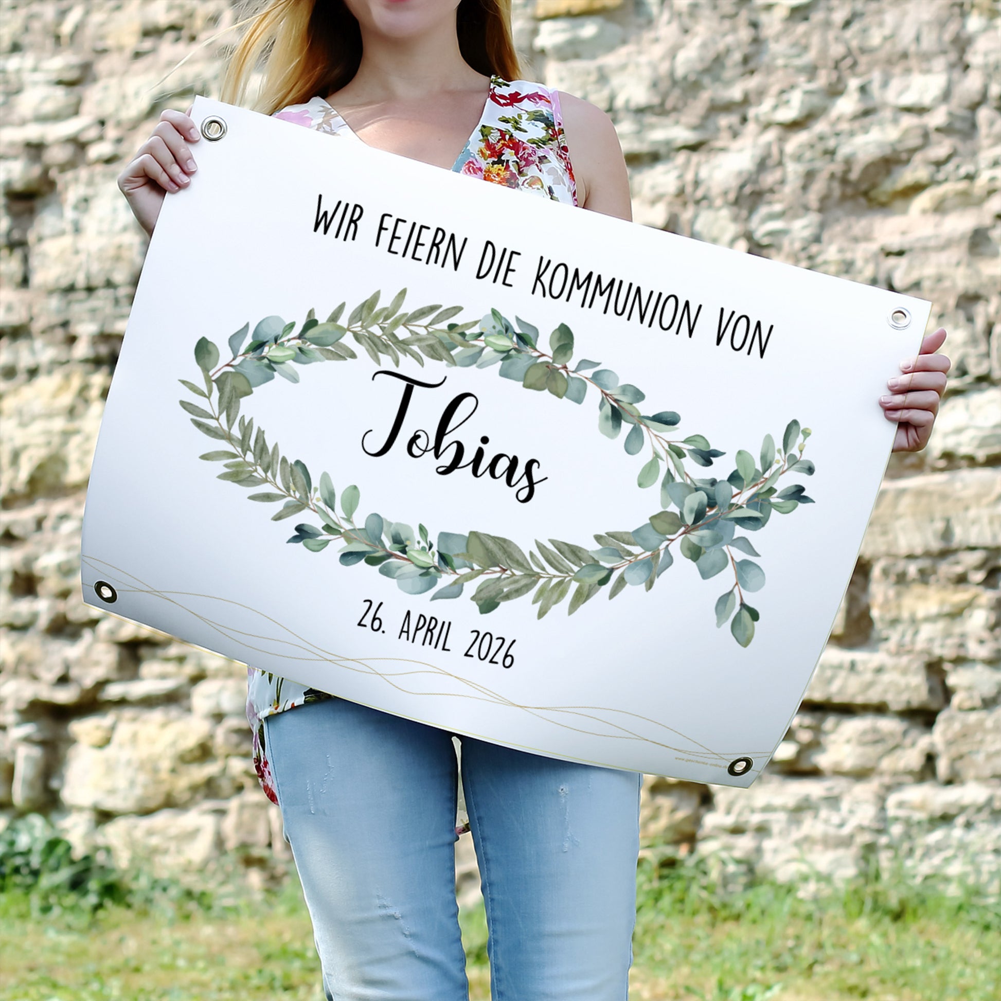 Poster-Banner mit christlichem Eukalyptus-Fischmotiv, Name „Tobias“ und Datum „26. April 2026“. Das Banner hängt über einem festlich gedeckten Tisch mit Kuchen, Obst und Blumen.