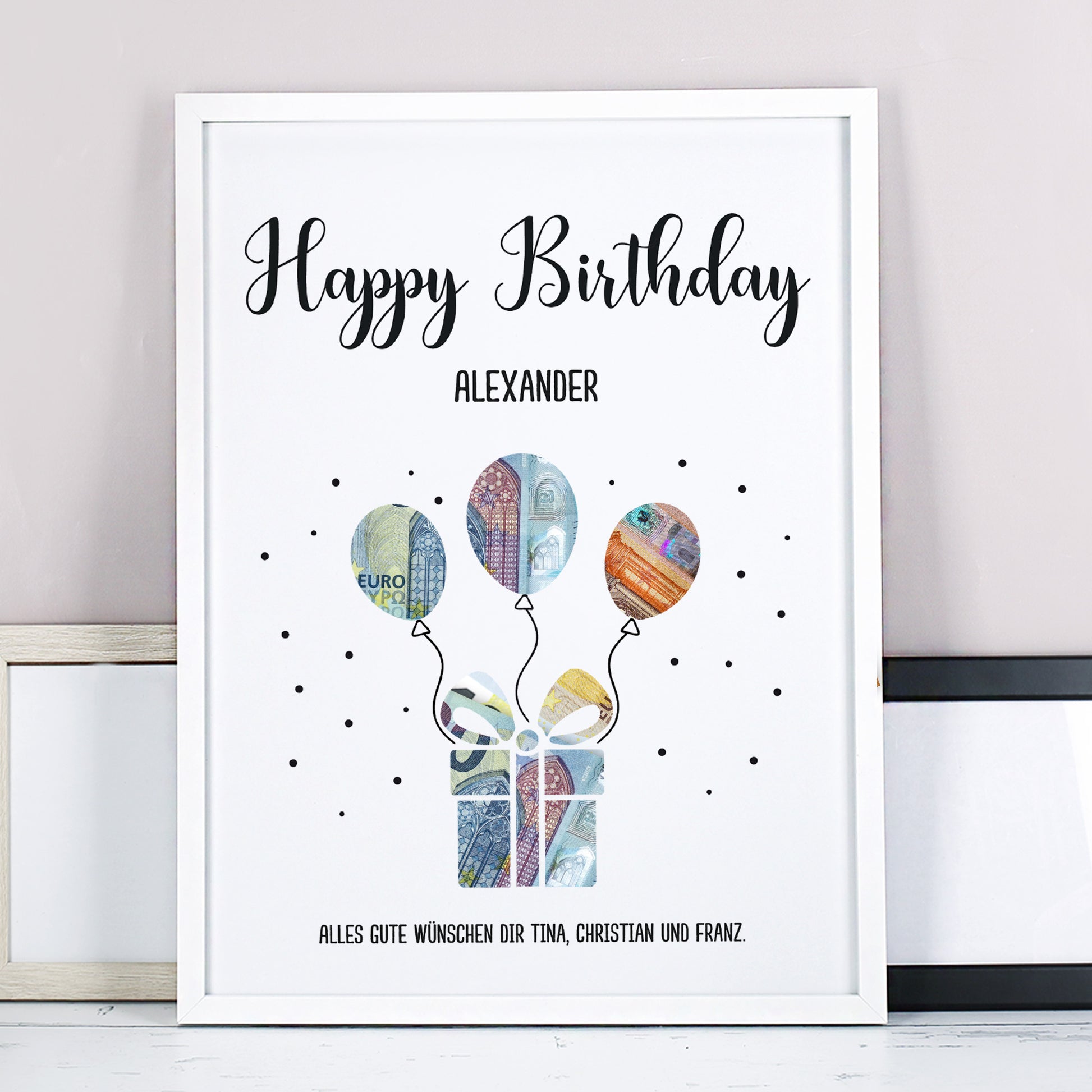 Wunscherfüller im weißen Rahmen mit Motiv „Happy Birthday“ für Alexander, gefüllt mit bunten Geldschein-Ballons