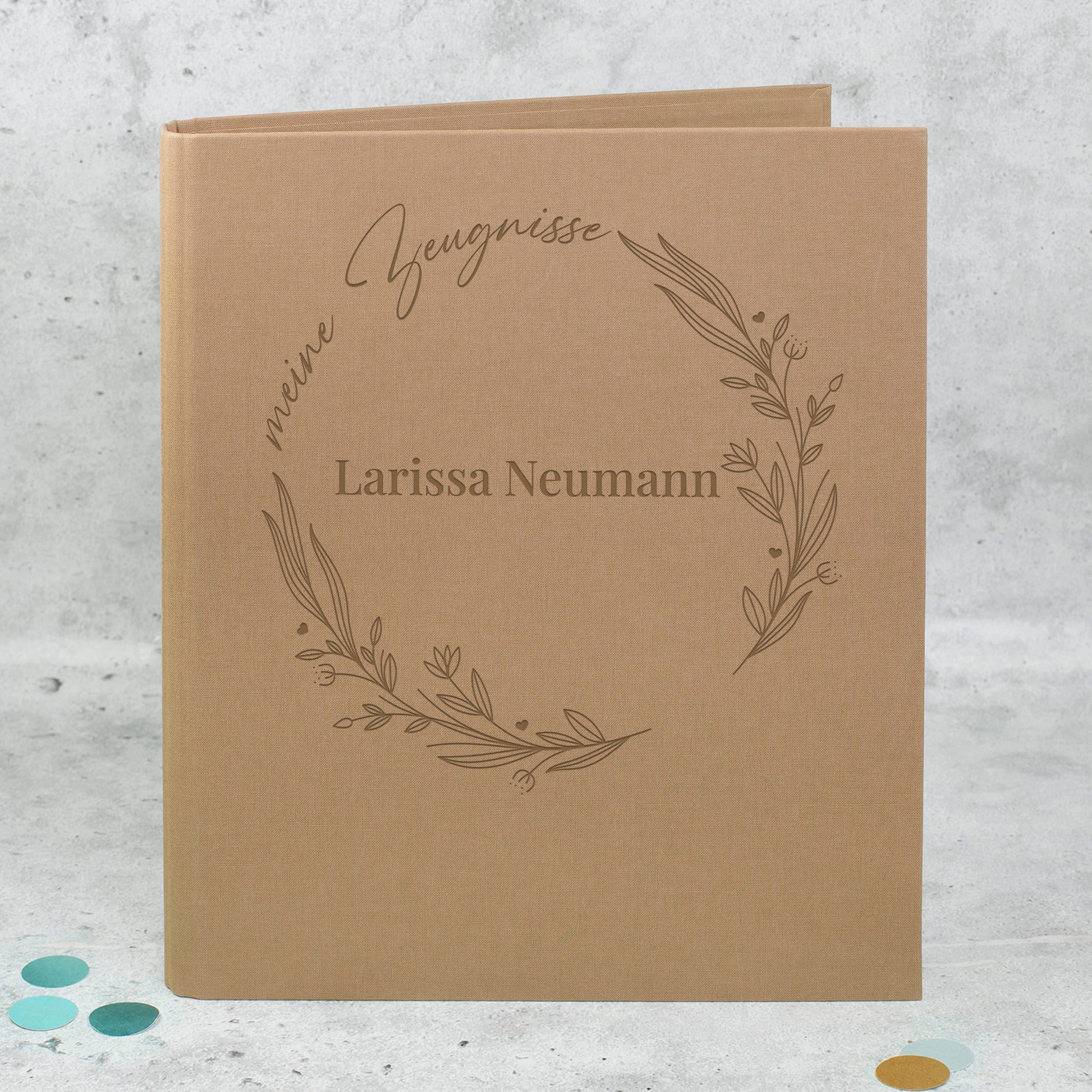 Braune Zeugnismappe aus Leinen mit floralem Lineart-Ring, Aufdruck „meine Zeugnisse“ und personalisiertem Namen „Larissa Neumann“.