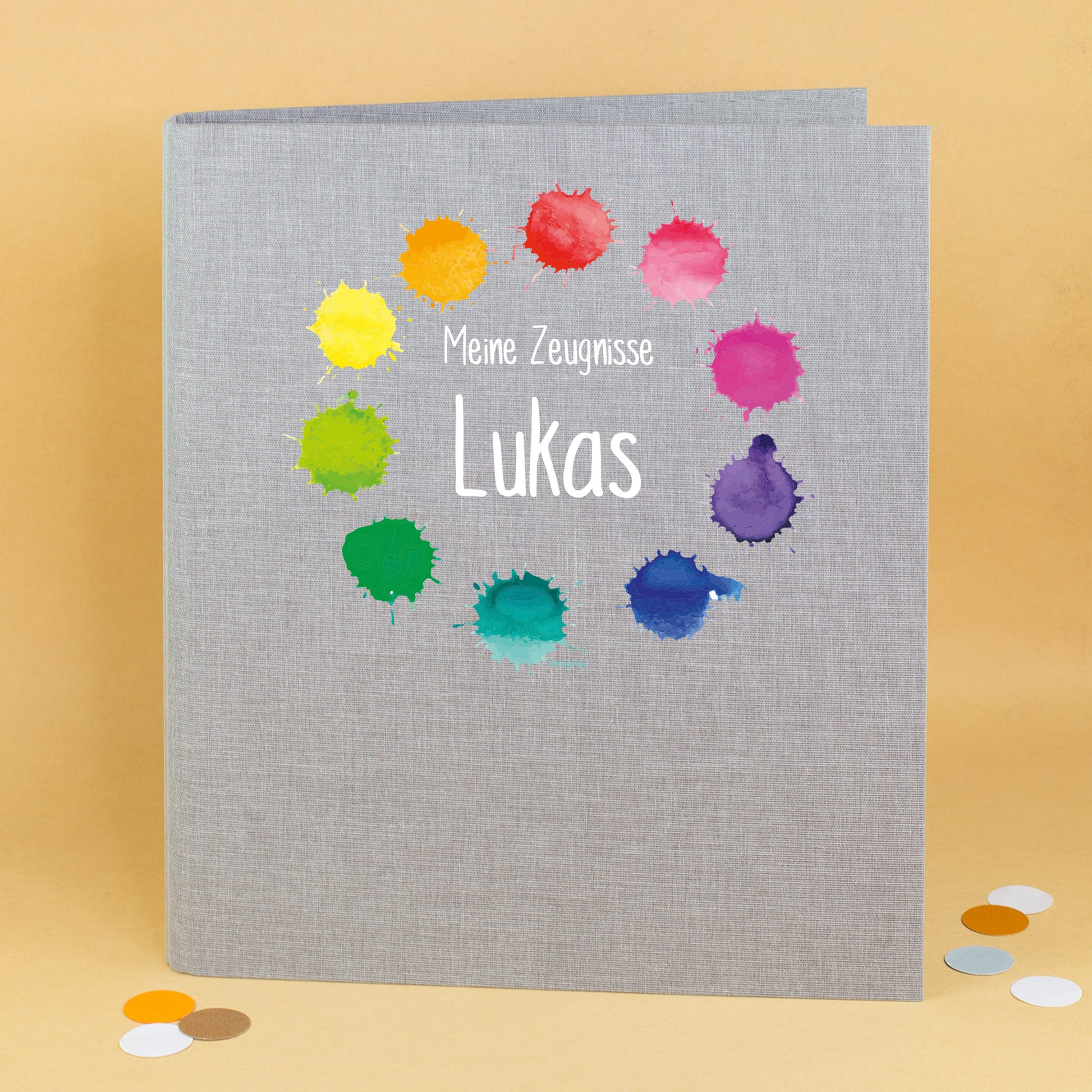 Zeugnismappe aus Leinen in Grau mit buntem Farbklekse-Motiv und Name Lukas bedruckt